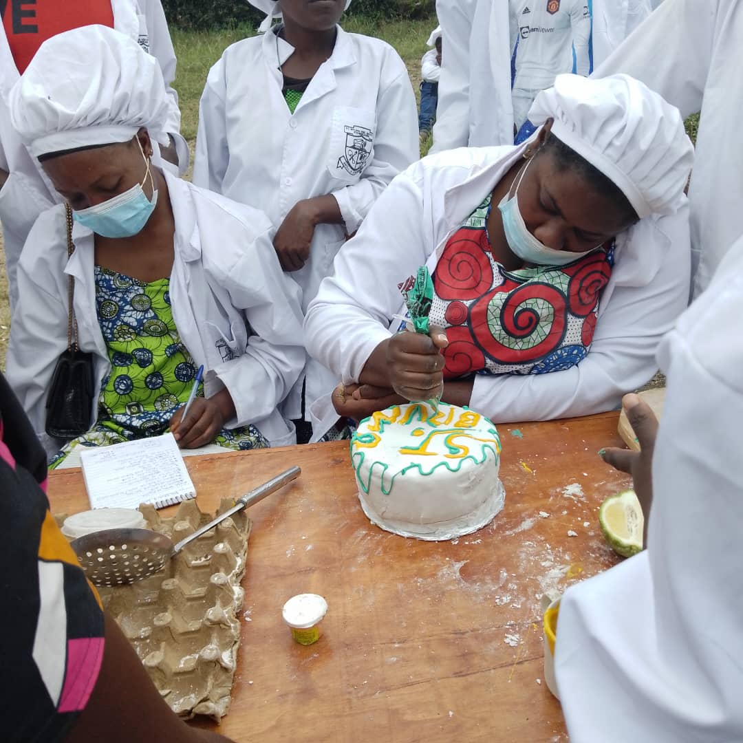 Catering learners decorating a cake during practical training